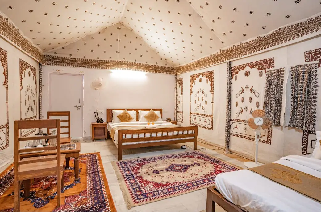 Royal Swiss Luxury Tent interior with traditional Rajasthani wall art